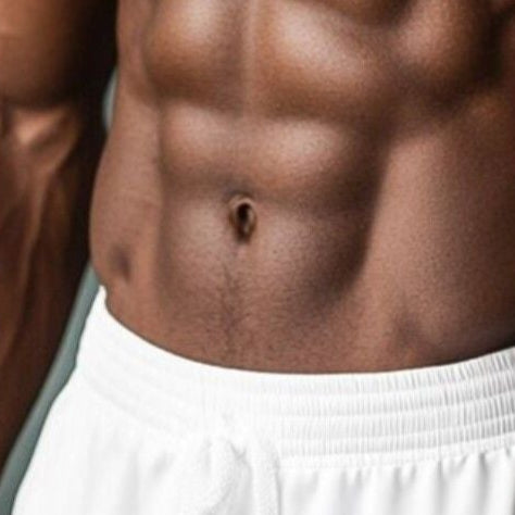 Muscular man with a fit physique wearing white shorts indoors.