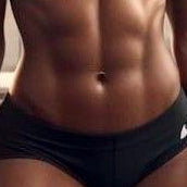 Athletic woman in black sports bra and shorts standing in a gym setting