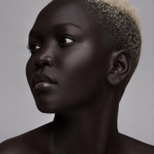 Woman with a short, styled haircut against a gray background