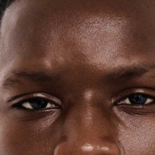 Close-up of a person with a neutral expression on a beige background